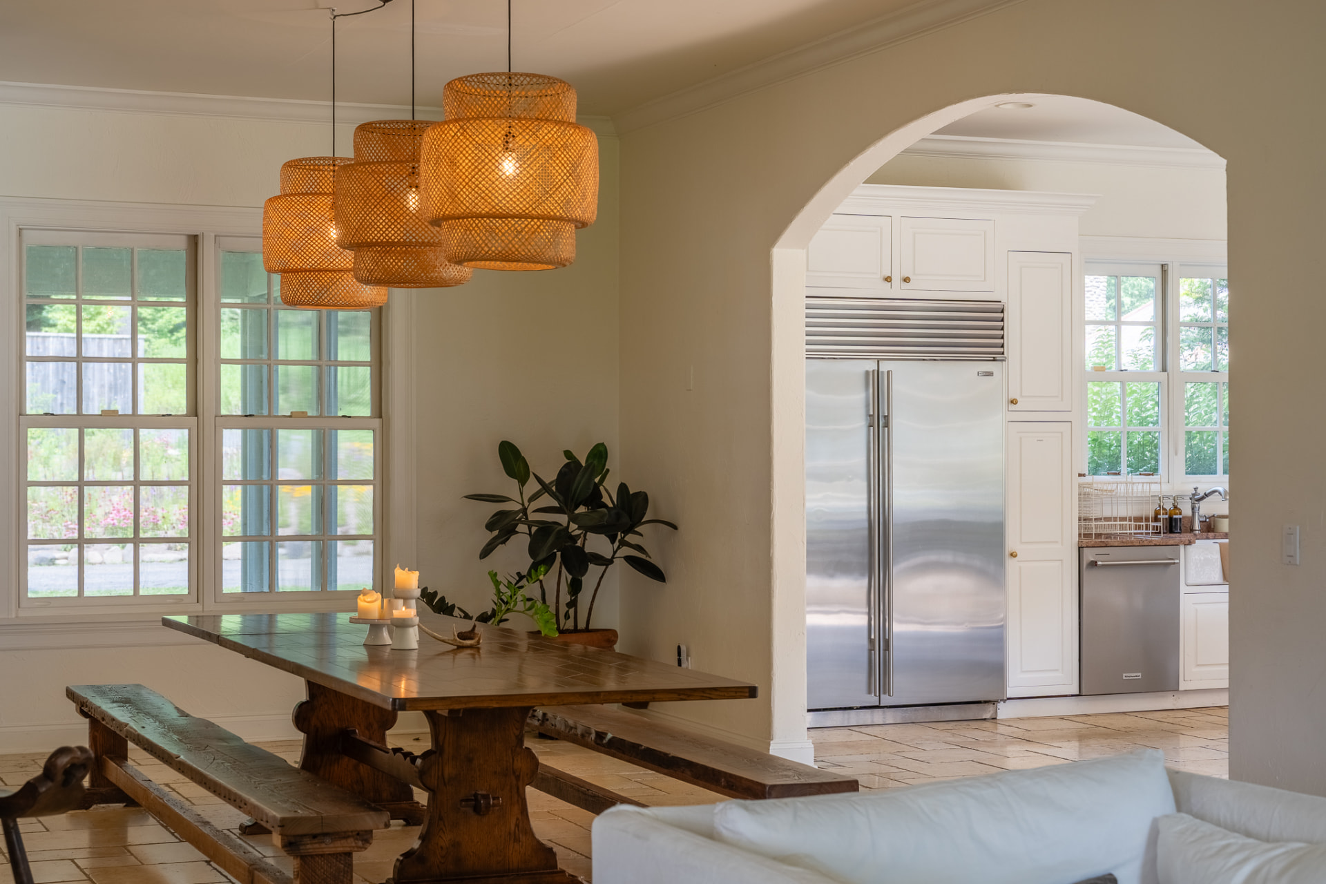 The long dining table at the Lundy House set beneath woven pendant lights